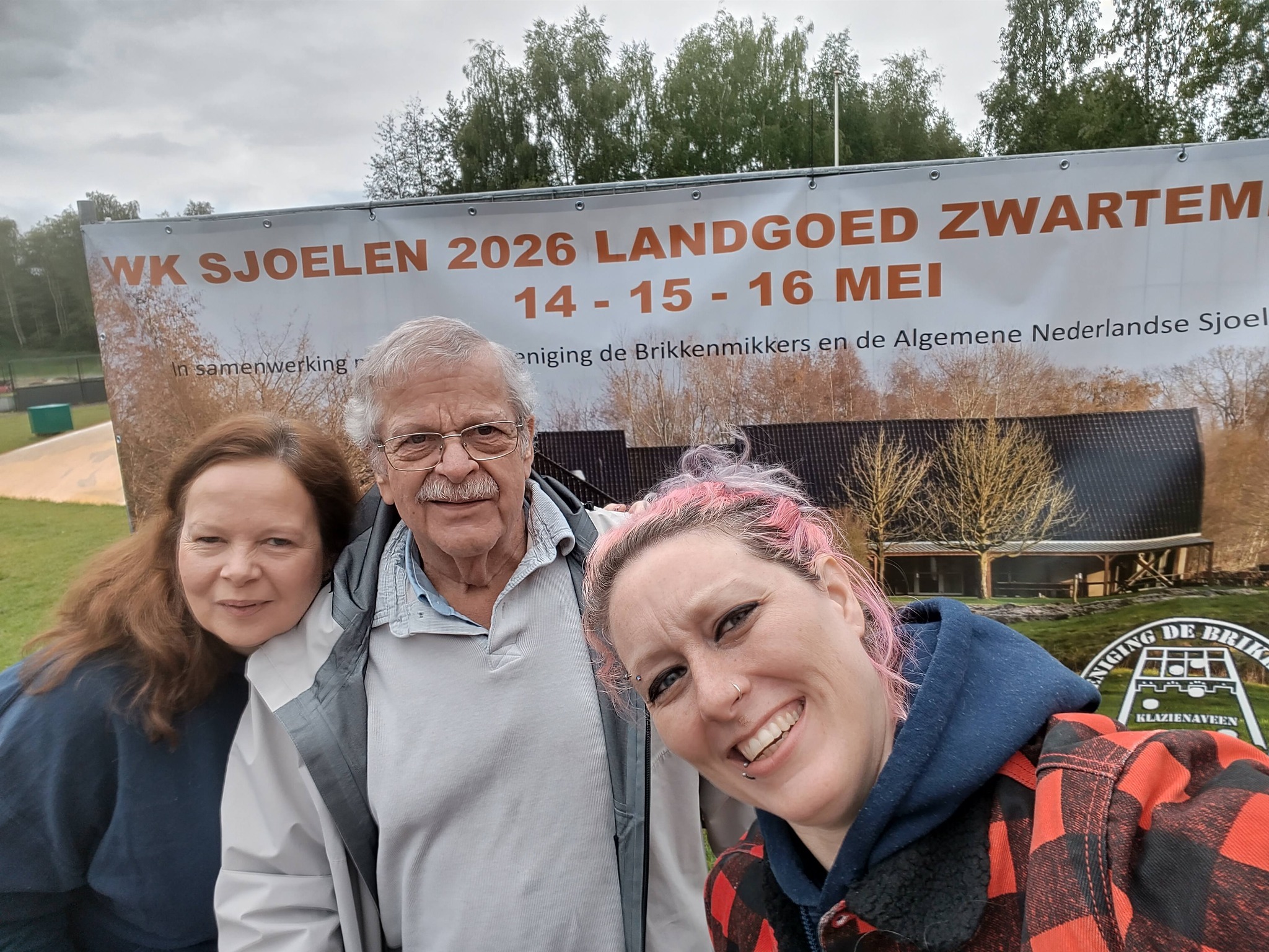 The three members of the UK sjoelen team in front of the welcome sign at the 2026 Sjoelen World Cup in Zwartemeer, Netherlands.